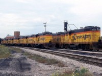 A large group of first Generation Geeps, the GP7's that killed steam in the 50's, sit stored and out of service at Chesapeake and Ohio's roundhouse/shops off Wilson Ave. in St. Thomas ON. Some of the units visible are C&O 5737, 5732 and 5730, all in matching Chessie System paint with their long hood doors secured, deemed surplus by their owner. Most were sold off ending up on shortlines and regionals.<br><br>Also worthy of noting is these particular units are Canadian-production (GMDD) GP7's, built in London ON for the C&O in 1951. 