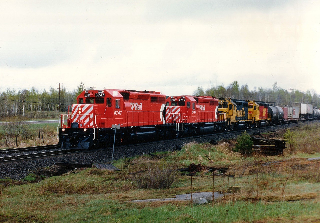 I was heading south on old Hwy 69 (now Nobel Rd here) and hoping to pick up a freight southbound when I heard chatter all of a sudden for a northbound. First spot I could think of was at Felsman Drive just south of Nobel. Not a good location, but at least in the rain I caught all 4 units in the few seconds I had to get the camera out. Good thing, too. Behind CP 5747 and 5740 were two of those elusive Santa Fe units that were on lease to CP for a short period in 1987. Around thirty of them were supposed to be out there, of which just one sported that "SF" paint scheme.  Lucky or what?  Units are 3615 and 3600.