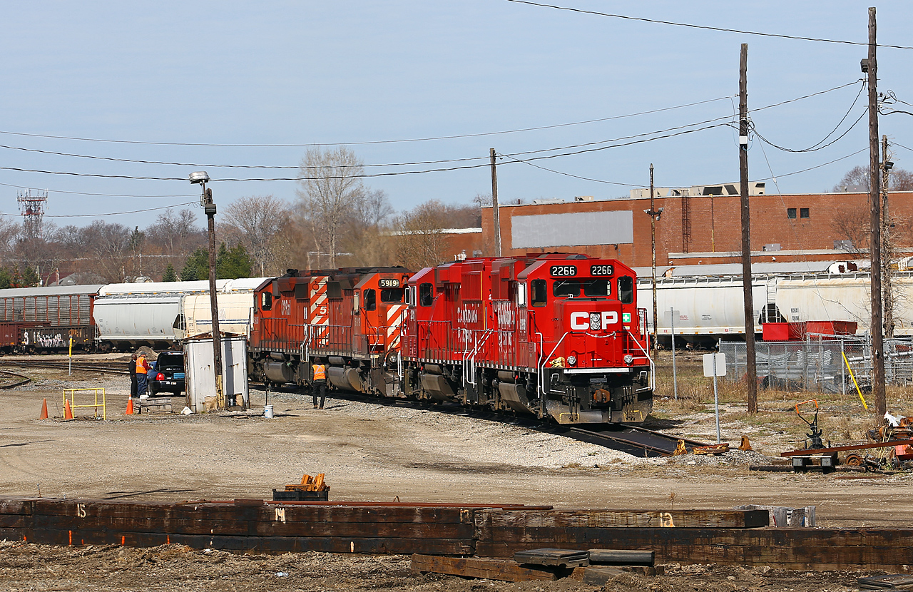 CP 235's power has cut off their train on the main and backed down the back lead to set off two GP20ECO's at the shop track. The train was recrewed here -  note the new crew pulling up in a limo! There are significant changes being made at the yard here including clean up at the east end of the yard, a new MOW storage area at the west end, brush cleanup and new switches to be installed. Power into town was CP 5926-5919-2211-2266. Geoff Elliot also caught this train west of London at Belle River.