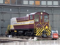Sitting recently painted in front of the former CPR John St. Roundhouse in downtown Toronto, CP 7069 (a 1948 Baldwin DS4-4-1000 switcher) rests on a stub track outside stall 14 sporting relatively fresh maroon and grey paint. Long stored inside out of view, it had been recently repainted from the action red with stripes that it wore for a number of years prior. One of only two Baldwin diesels saved from CP's roughly two-dozen they once rostered, it's a long way from home in Vancouver where it was based out of for most of its life.
<br><br>
There's an interesting story behind this unit. 7069 was retired in the late 70's, incurring a cracked engine block from freeze damage (with less than stellar attempted repairs). It was then purchased by a pair of individuals and moved to Toronto. One account states that they insisted on that particular unit for some reason, even though there were other operable units around and the person in charge tried to convince them to purchase one of those when they were retired (they apparently also cleaned out the shop of a whole wack of Baldwin parts for it). 7069 was moved to Toronto, and had been stored in the old John St. roundhouse in downtown Toronto, out of view of the public, for years before a museum was established. It currently resides there, but is somewhat of an oddball and unloved due to its west coast heritage, and will likely never run again due to its cracked engine block. Current ownership is a bit questionable, and it was in danger of being scrapped for a bit when Leons was moving in and the City of Toronto wanted it moved out or they would dispose of it (see <a href=http://torontoist.com/2007/07/say_goodbye_to_1/><b>The Hauling Fool</b></a>).