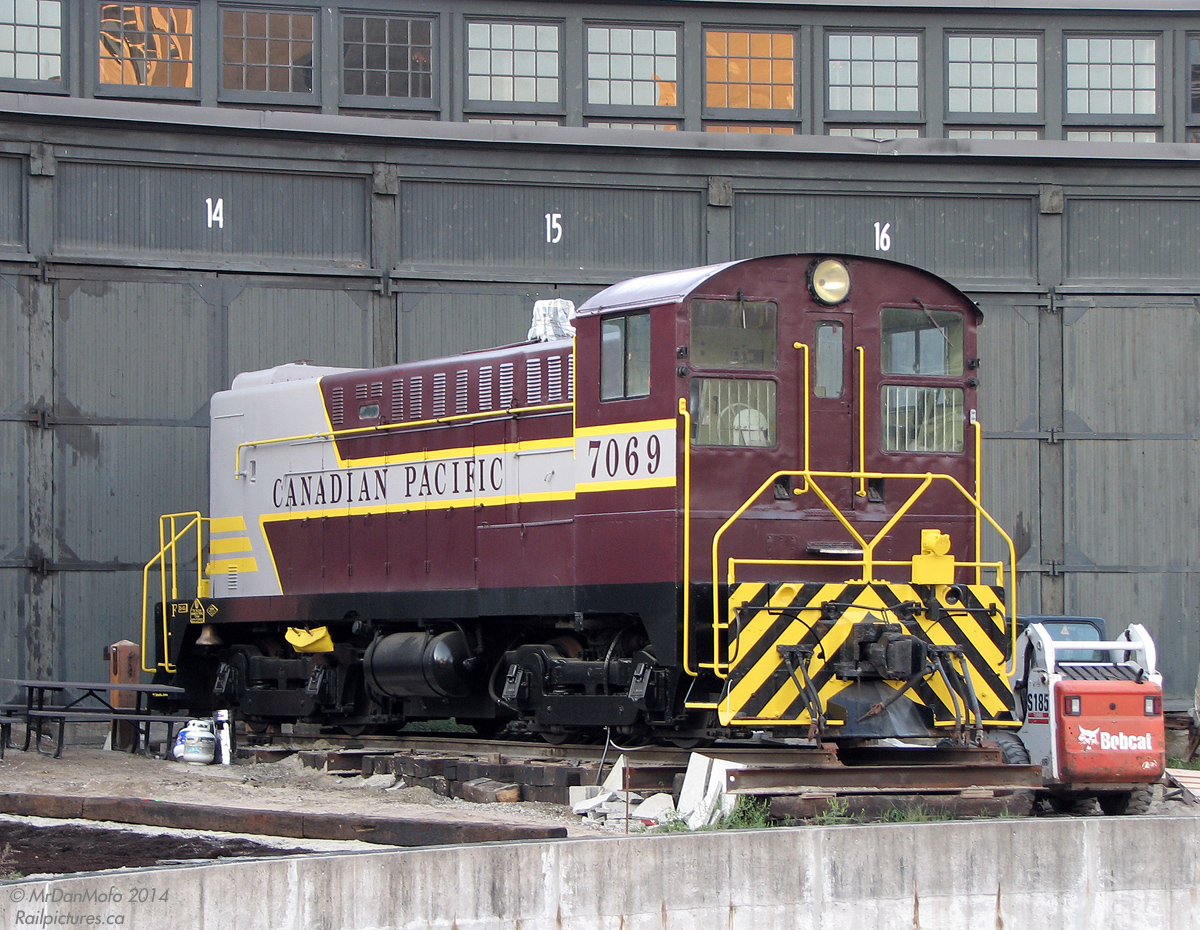 Sitting recently painted in front of the former CPR John St. Roundhouse in downtown Toronto, CP 7069 (a 1948 Baldwin DS4-4-1000 switcher) rests on a stub track outside stall 14 sporting relatively fresh maroon and grey paint. Long stored inside out of view, it had been recently repainted from the action red with stripes that it wore for a number of years prior. One of only two Baldwin diesels saved from CP's roughly two-dozen they once rostered, it's a long way from home in Vancouver where it was based out of for most of its life.

There's an interesting story behind this unit. 7069 was retired in the late 70's, incurring a cracked engine block from freeze damage (with less than stellar attempted repairs). It was then purchased by a pair of individuals and moved to Toronto. One account states that they insisted on that particular unit for some reason, even though there were other operable units around and the person in charge tried to convince them to purchase one of those when they were retired (they apparently also cleaned out the shop of a whole wack of Baldwin parts for it). 7069 was moved to Toronto, and had been stored in the old John St. roundhouse in downtown Toronto, out of view of the public, for years before a museum was established. It currently resides there, but is somewhat of an oddball and unloved due to its west coast heritage, and will likely never run again due to its cracked engine block. Current ownership is a bit questionable, and it was in danger of being scrapped for a bit when Leons was moving in and the City of Toronto wanted it moved out or they would dispose of it (see The Hauling Fool).