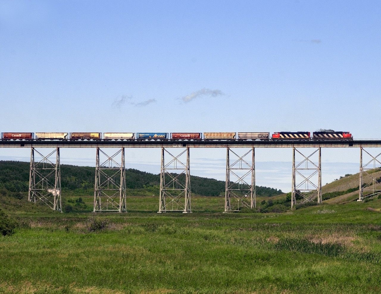 An eastbound grain train crosses Cutarm Creek in eastern Saskatchewan just east of the massive Esterhazy K2 Potash mine.