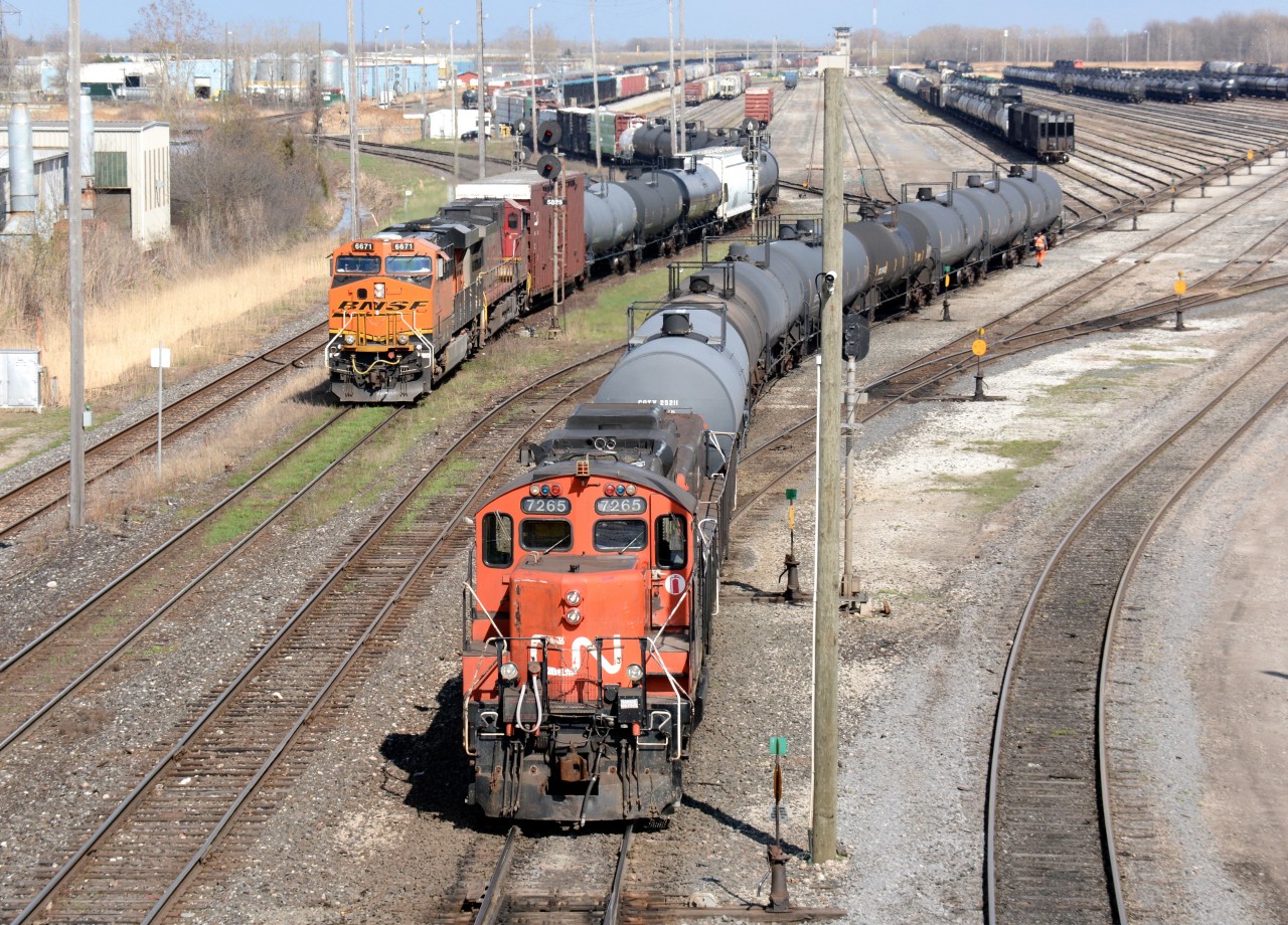 CN7265 with slug 231 shunts in the Sarnia yard while CN train 501 starts its roll towards the St. Clair River tunnel.