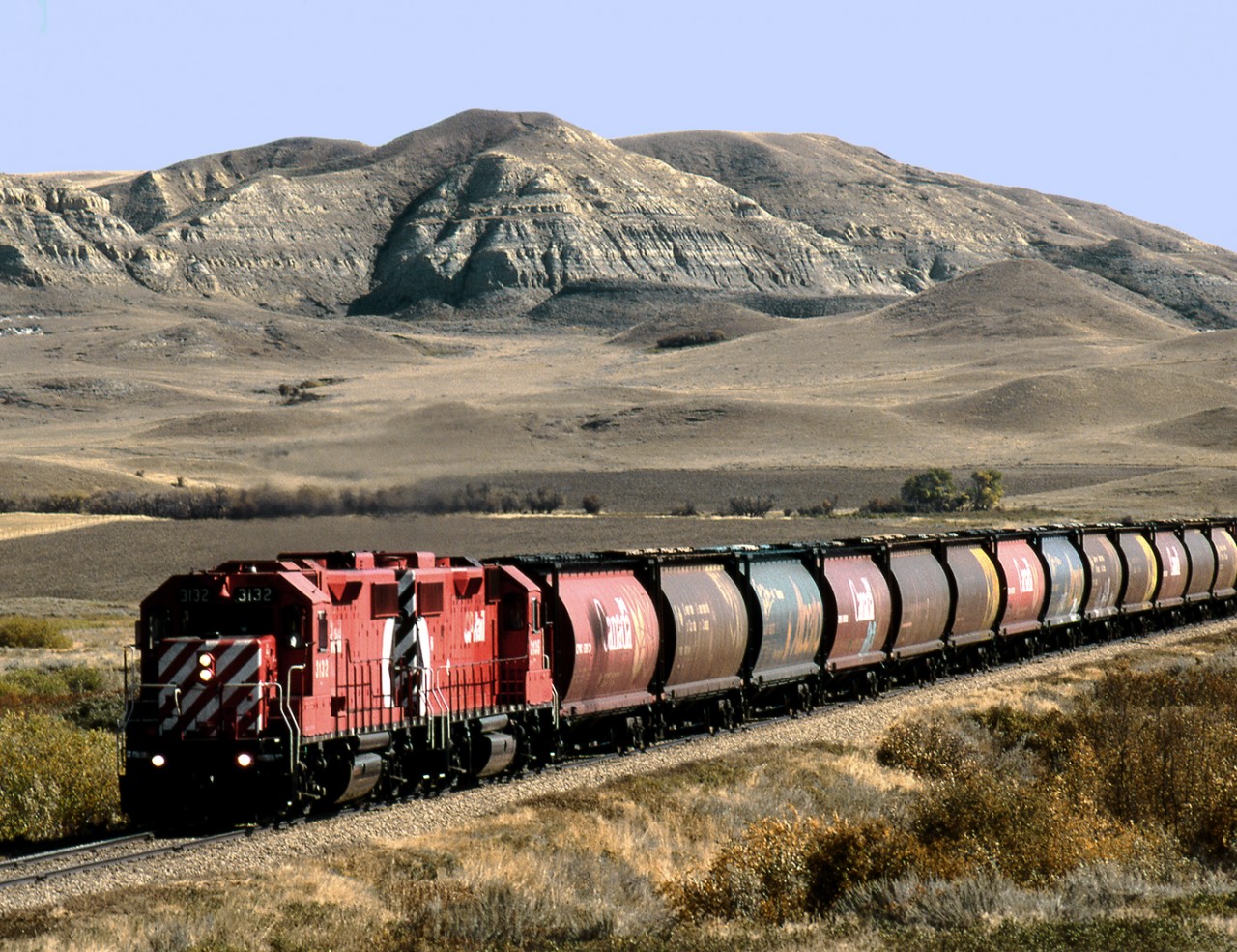Grain spotting tramp out of Shaunavon Sask. bound for Val Marie on the Noyukeu Subdivision passes the Ravenscrag Butte in the Frenchman River Valley west of Eastend Sask. Line is now part of Great Western Rail lines.