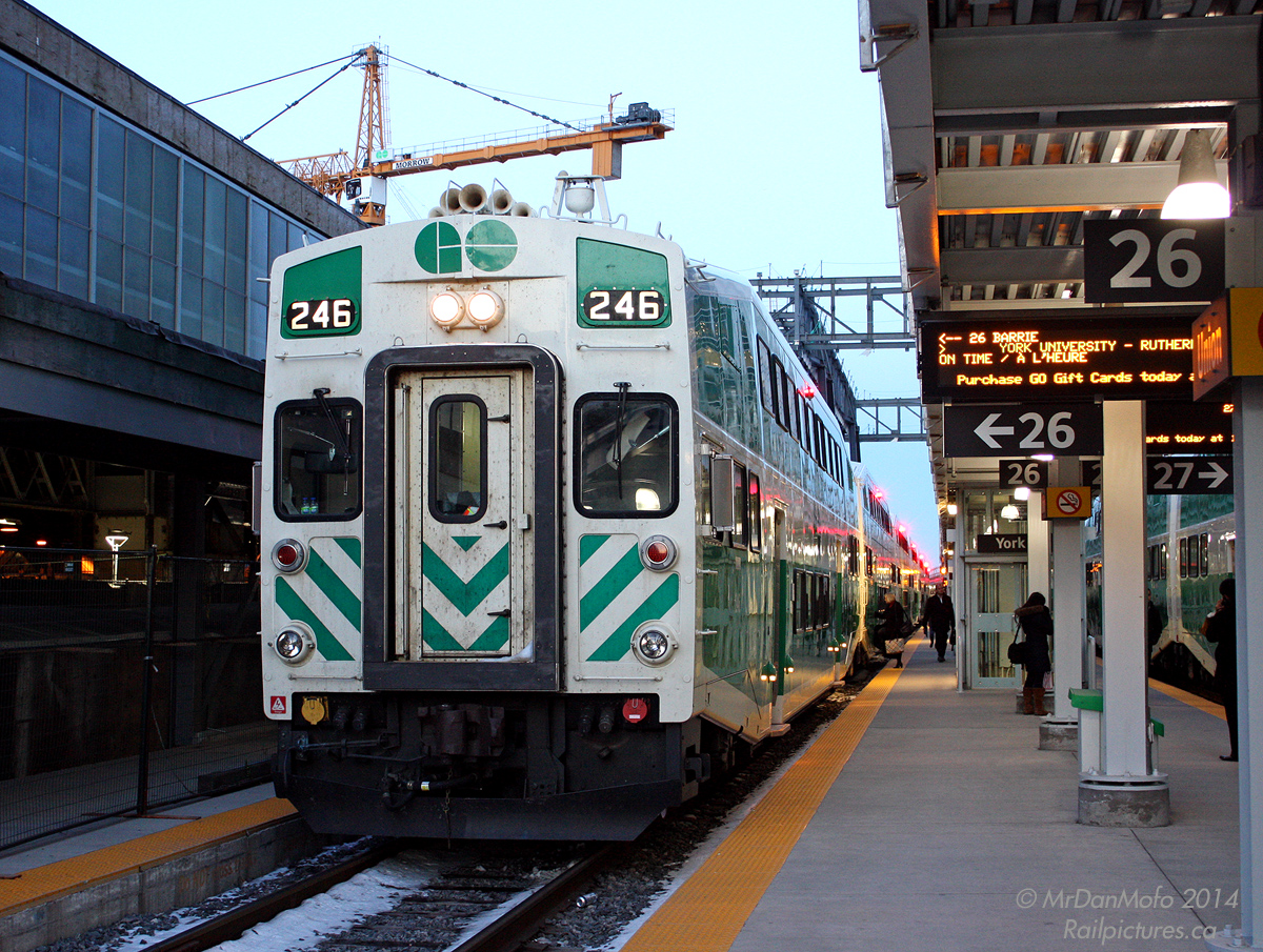 Passengers board GO Barrie line train 809, on time, parked at Platform 26 at Toronto's Union Station. In the background you can see the tower crane and massive steel framework for GO's new train shed "Atrium" (part of the ongoing Union Station renovations), on the right another GO Train for the Milton line, and on the left part of the old Track 11/12 train shed extension undergoing renovations. A slightly dirty but still shiny Bombardier bilevel cab car 246 leads 809, the 18:05 to Barrie, this evening.