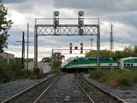 Just another day - back then. Today, history. <br><br> Framed in the westbound CP signaltower, GO MP40 611 pushes a 10-car train full of Etobicoke, Brampton and Georgetown-bound commuters north through "The Junction" neighbourhood of Toronto, clattering over two of the four interlocking diamonds that have for decades allowed north/south traffic on CN's Weston Sub to cross CP's North Toronto Sub, their busy crosstown line across midtown Toronto. This is "West Toronto Diamond". <br><br> GO's new MP40PH-3C's are most recent in a long line of power to "bang the diamonds" of West Toronto for decades, including steam engines, first-generation diesels, Budd RDC's, various transcontinental and local passenger trains, and the endless stream of freights, transfers and locals from both CN & CP. All this would come to an end a little over 5 years after this photo was taken: after the PM GO rush on May 23rd 2014, a workblock was put up on the line, in order to divert the Weston Sub's track from the remaining diamonds to the brand new flyunder, part of the West Toronto Grade Separation project allowing passenger trains to seamlessly cross underneath the CP tracks and eliminating any delays caused between the two. With the work taking place on the weekend, Monday's GO trains will be the first not to click-clack over CP's line.