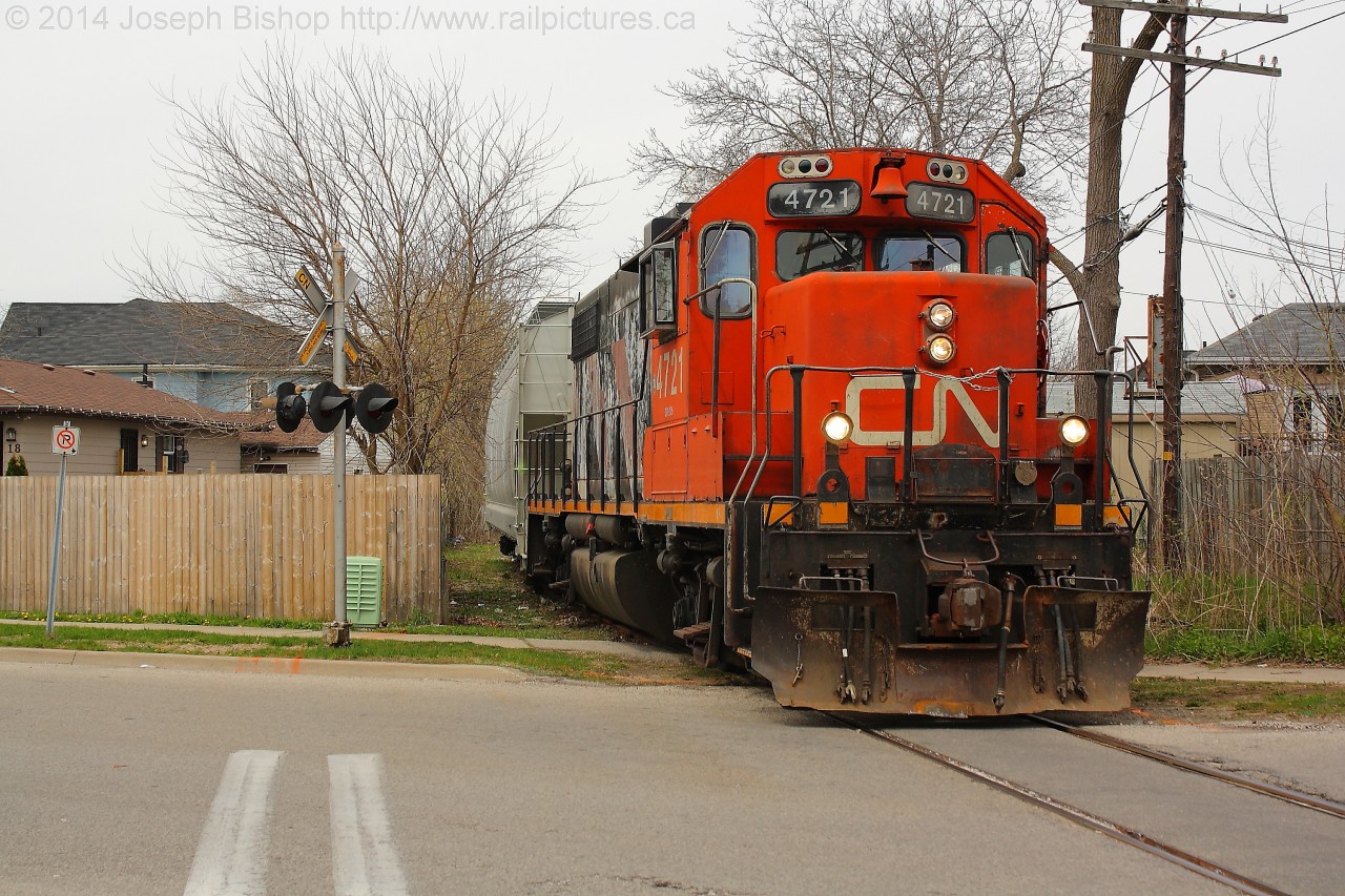 CN 4721 leads a single hopper down the Burford Spur, they are seen here crossing Cayuga Street on their way to Ingenia.