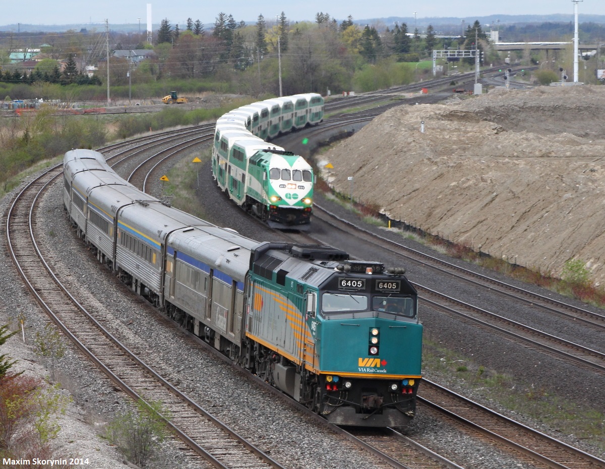 VIA Rail racing GO Transit.... on 2 different subdivisions! Here we see 2 Eastbound passenger trains "racing". The VIA Rail is on the CN Kingston subdivision and the GO Transit is on the GO GO subdivision. Since the Lakeshore East Line is one of the most heavily used by GO Transit, they decided to build their own subdivisions right next to CN's. Anyone notice the difference in ballast?