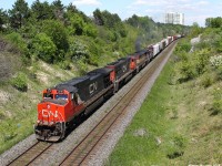On a very hot and sunny day in May, a westbound Canadian National train with a one of a kind lash-up goes by Hilda. At the last position, is CCGX 1004 showing CANDO on the side in black paint, which is a yard switcher. Any info on that would be appreciated.