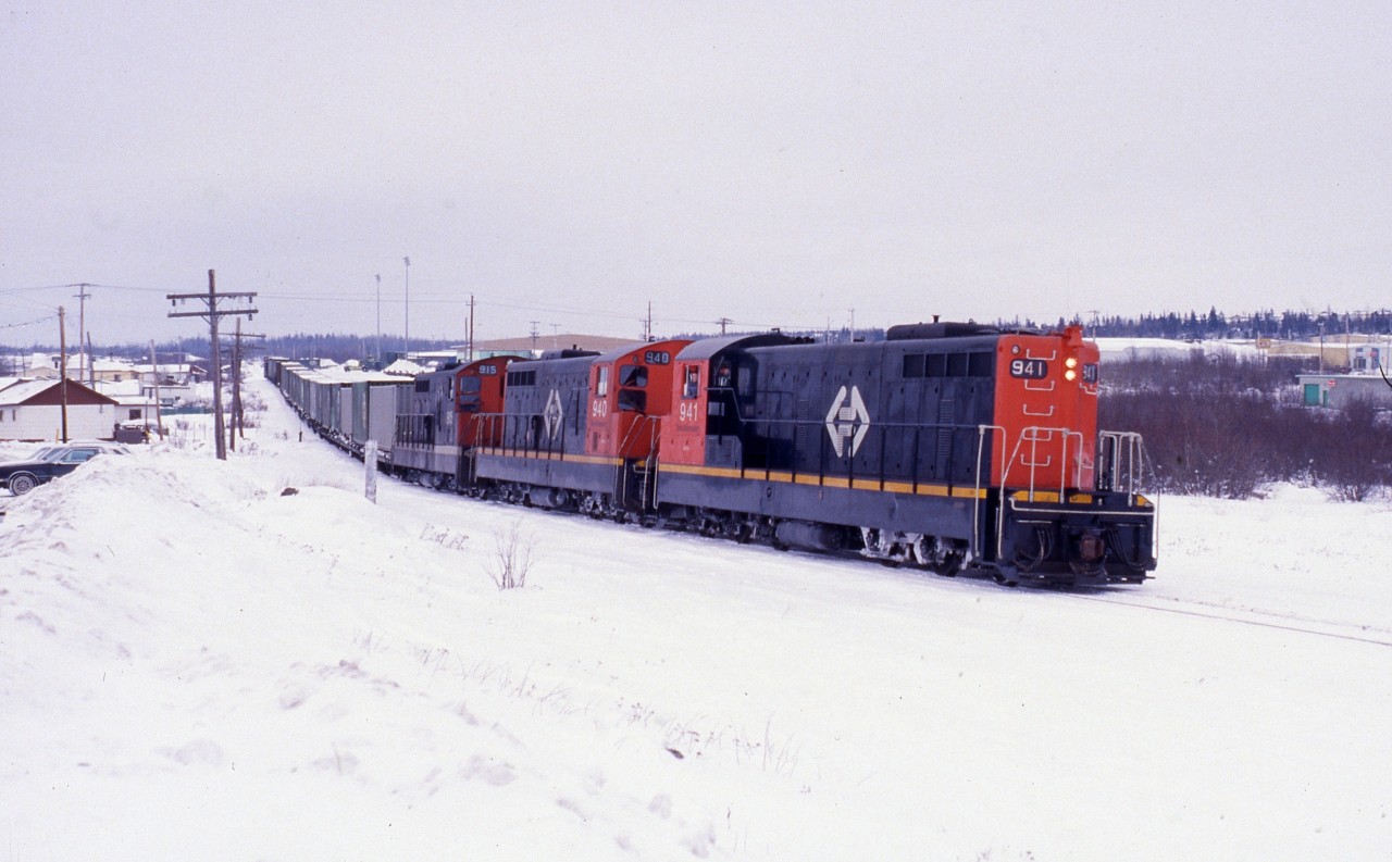 Christmas week 1987 finds Engineer Ray Boyd at the controls of Terra Transport Mixed Extra 941 West about to depart from Grand Falls for Corner Brook. Just days after this photo was taken, a CTC rule saw the coach service removed from the consist until the following April. For the first three months of 1988, Terra Transport would operate the train formerly known as # 203 as a freight only service.This photo with it's modern day counterpart  and many others can be seen in 'RAILS ACROSS THE ROCK - A Then & Now Celebration of the Newfoundland Railway' by Kenneth G. Pieroway and published by Creative Book Publishing of St. John's, Newfoundland. Photo by author.