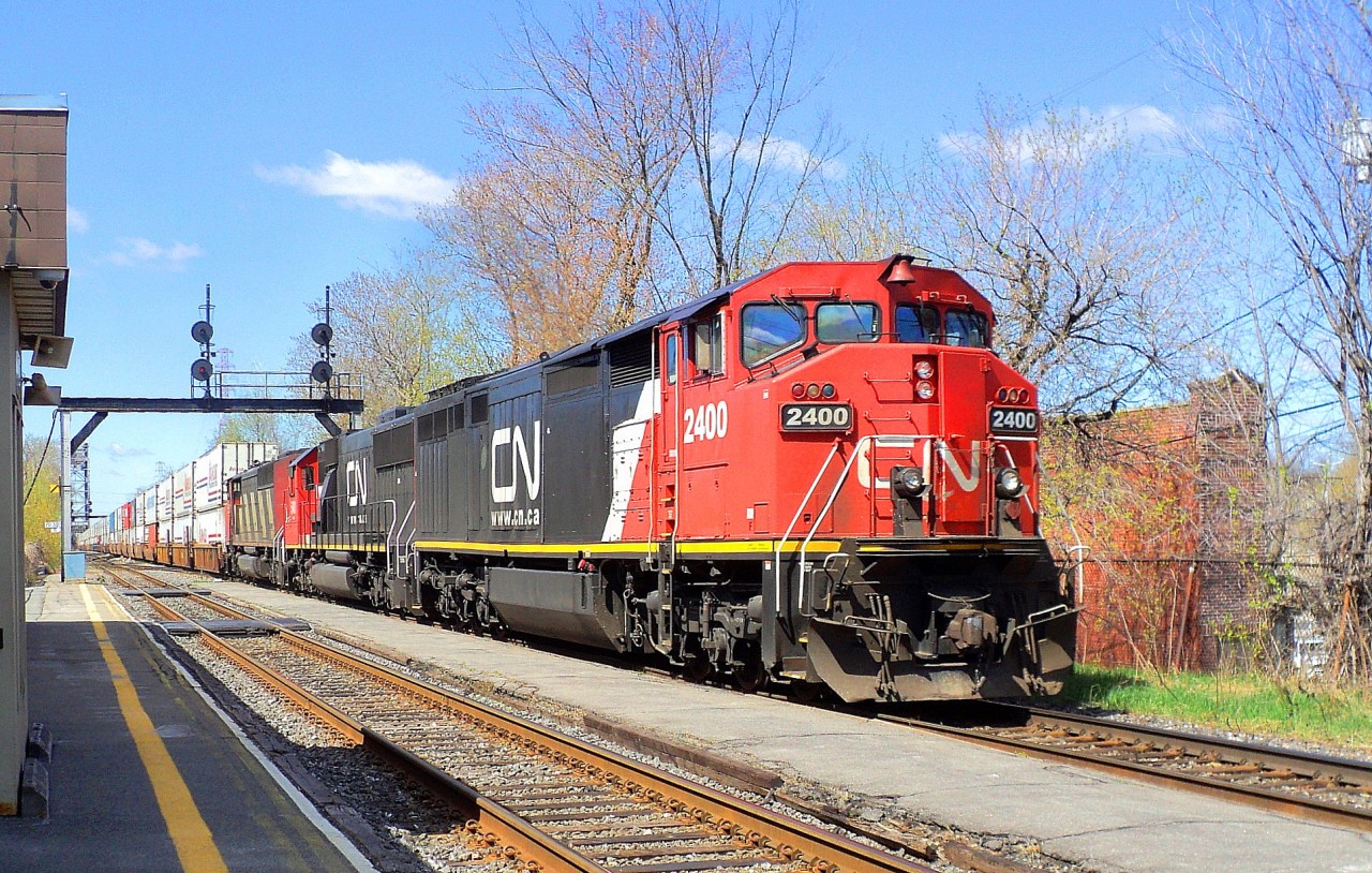 CN_2400 a C-40-8W leading loco follow of CN-5481 a SD-751 and a third locos that I do not have the number pulling a convoy of containers going in the Maritimes up to Halifax N.S. CN-route 120