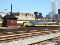 Ontario Northland's Northlander, made up of an FP7-TEE trainset, has departed Union Station in the downtown core of Toronto, enroute to northern Ontario on this Sunday departure back in March of 1984. At Bathurst Street brige about to leave the Toronto Terminals Railway corridor, the train is passing the old Cabin D interlocking tower, heading to the CN's Weston Sub to get to the Newmarket Sub at Parkdale.
<br><br>
While the Northlander's final run was in September of 2012, and the FP7's and TEE equipment is long retired, Cabin D survives and currently rests at the nearby Toronto Railway Heritage Association's Roundhouse Park in restored condition, according to their website it was moved there later in 1984. 