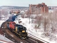 View from Main St. overpass looking NW toward the former Ottawa Valley(CP) yard that has now been moved south of the city in order to free up valuable waterfront/downtown lands. OVR 4204 and OSRX 504 are seen working a long cut of cars. The 4204 was acquired in 1996 and shortly after this photo was taken departed for Lakeland and Waterways startup in Alberta that September. It has since been retired. The second unit, former CP 8044, renumbered 504 assigned Guelph Jct Rwy, was on loan. It today still smokes-up on the GJR.