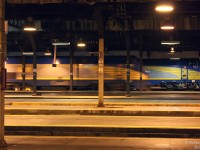 A quiet eventing under the train shed of Toronto Union Station is disrupted by the clanging of an E-bell, as VIA P42 909 departs off Platform 17 with #67, the 22:05 for Aldershot (tonight made up of Renn cars). In the background, VIA 913 idles along Platform 20 on #89 for London, awaiting its departure time 5 minutes later at 22:10 (with a HEP baggage tucked ahead of its usual LRC cars). Except for the odd arrival and departure of a GO train, it will remain calm under the sodium lights until the bustle of Friday rush hour rolls around tomorrow morning.
