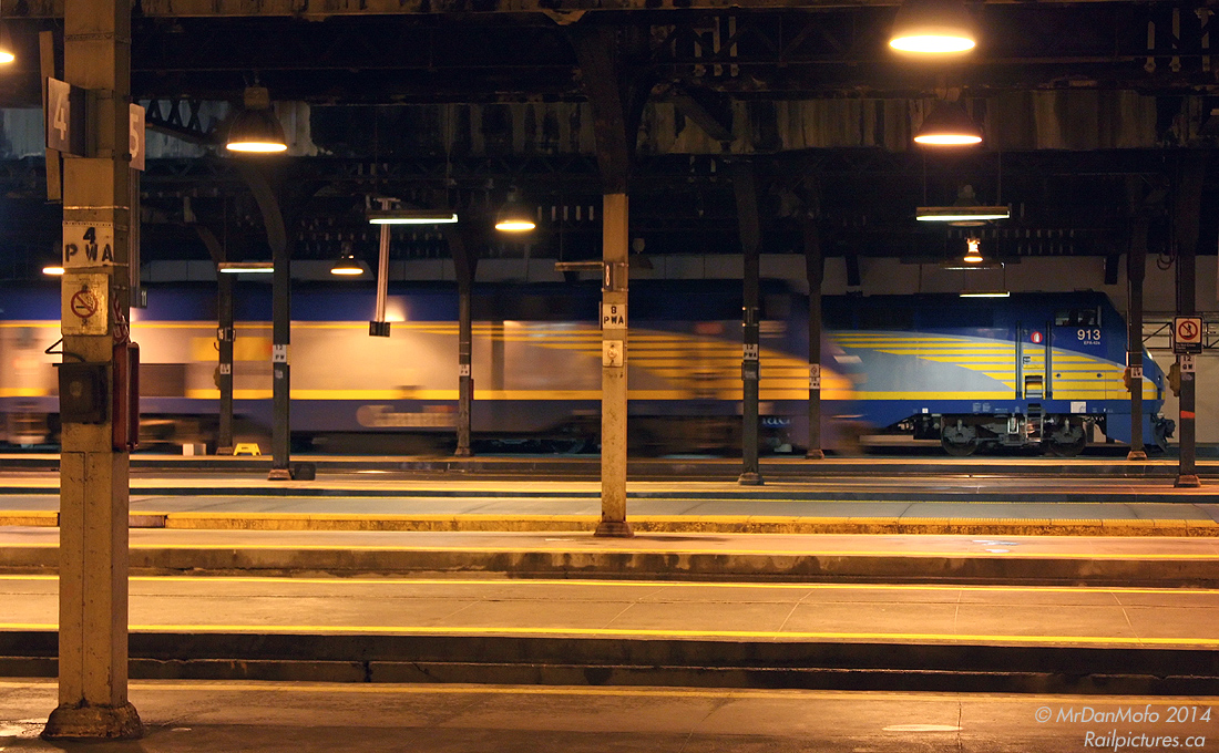 A quiet eventing under the train shed of Toronto Union Station is disrupted by the clanging of an E-bell, as VIA P42 909 departs off Platform 17 with #67, the 22:05 for Aldershot (tonight made up of Renn cars). In the background, VIA 913 idles along Platform 20 on #89 for London, awaiting its departure time 5 minutes later at 22:10 (with a HEP baggage tucked ahead of its usual LRC cars). Except for the odd arrival and departure of a GO train, it will remain calm under the sodium lights until the bustle of Friday rush hour rolls around tomorrow morning.