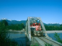 BCR #12 rolls across the Mamquam River bridge at Squamish, British Columbia on a cloudless day in May of 1992.