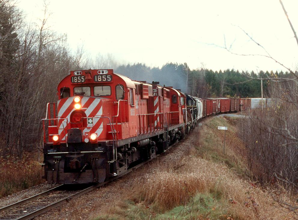 CDAC "905" races upgrade at Racey, Quebec with 2 borrowed CP RS18u's leading 3 Bangor & Aroostock "geeps" eastbound during the early days of the Canadian American Railway.