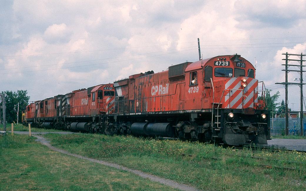CPR Extra 4739 east rolls into Sherbrooke, Quebec in August of 1987 with 7 other units trailing behind her, including 2 Chessie GP40 lease units.