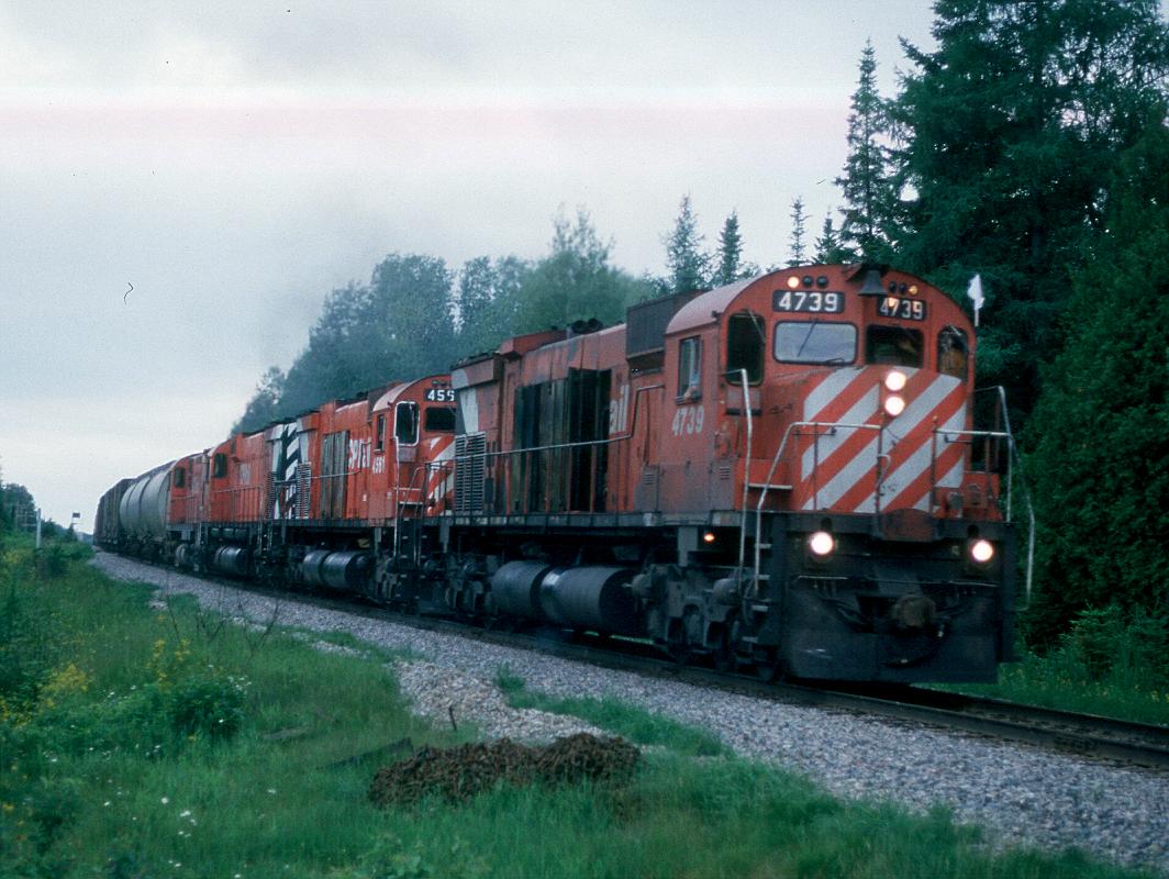 Jerry Albertie leans into the firemans door with my video camera in hand to shoot me taking a photo as Extra 4739 East crawls over Gould summit in June of 1987. The second unit was shutting down constantly due to over heating so was brought on line just when it was needed. On this stretch of railroad, that would be almost all the time!