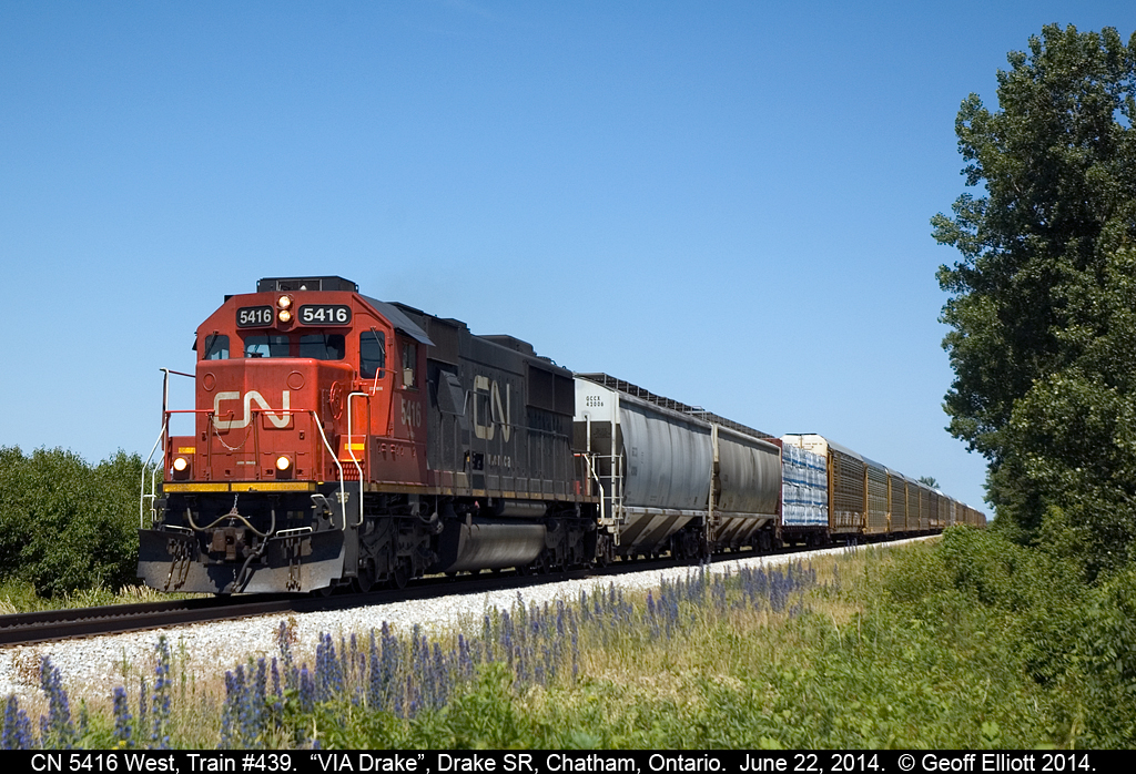 CN train #439 speeds across Chatham/Kent as it is about to cross the Drake Sideroad at "VIA DRAKE" with an SD50 running solo today.  439 is now significantly larger than it used to be now that CN has won the contract for loading autoracks out of the old GenAuto facility in Windsor.