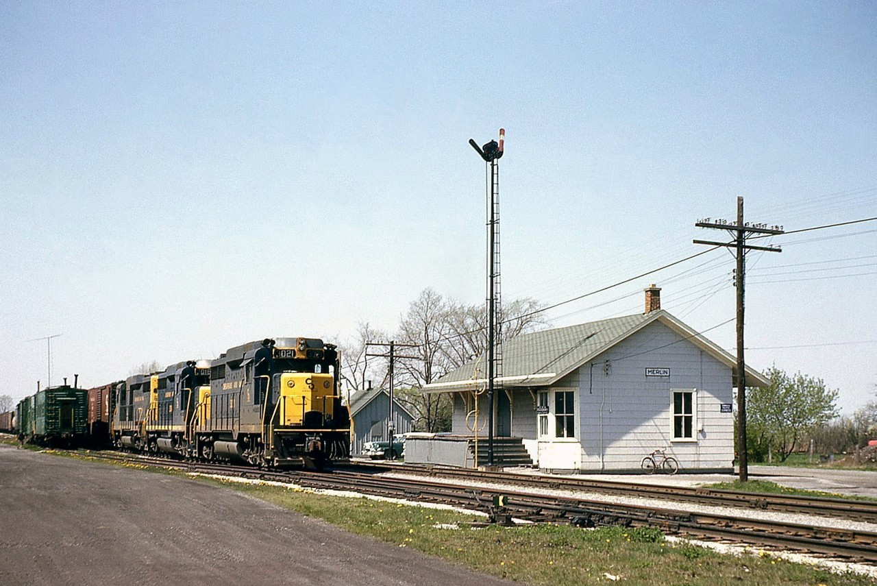 The third of the series of shots of Merlin in May 1964, here's a clearer view of the Chesapeake and Ohio Merlin Station and surrounding area. In the scene are semaphore signals, train hoops, MofW boxcars, a bicycle leaning on the side of the station, and of course the 3-pack of nearly new EMD GP30's. C&O 3021 is leading this eastbound, waiting on a meet with a C&O westbound.

* View of the train and its three GP30's: http://www.railpictures.ca/?attachment_id=14844
* Meeting the westbound with two sisters: http://www.railpictures.ca/?attachment_id=14951
