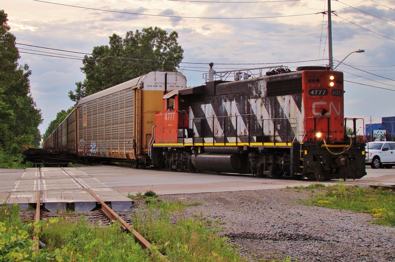 CN 4777 has 40 empty racks in tow as he heads for a loading facility near Jefferosn Ave. and The E.C. Row. CN has recently picked up the switching contract for Chrysler from CP and this is one of many daily locals out of Van de Water Yard that will traverse the City with auto Traffic for Chrysler.