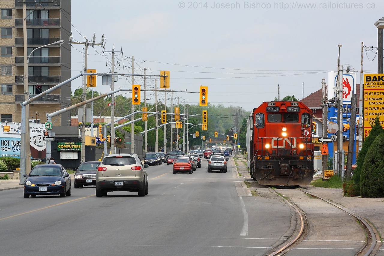 CN 4721 trundles down the Burford Spur with some traffic for Ingenia.  They are seen paralleling Clarence Street through downtown Brantford, shortly they will stop to trigger the traffic lights to allow them to cross over the short street running portion of the spur and continue on to Ingenia.