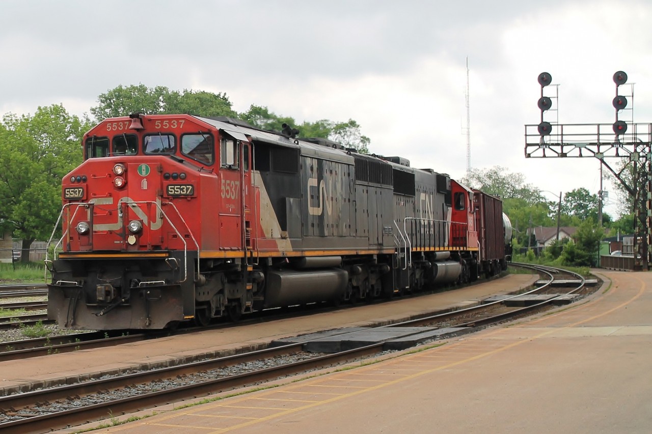9:45 on a hot, humid, overcast day, two SD60 of different styles, 5537 and 5455 lead 711 west with a string of tank cars. 5537 has the map of North America on the side instead of the usual zebra stripes!