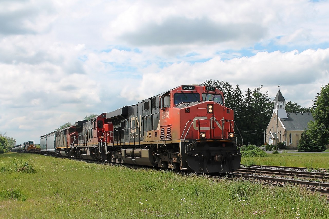 13:46 A mixed freight with a lot of Cargill hoppers and tank cars move quickly up the bank eastbound at Princeton.