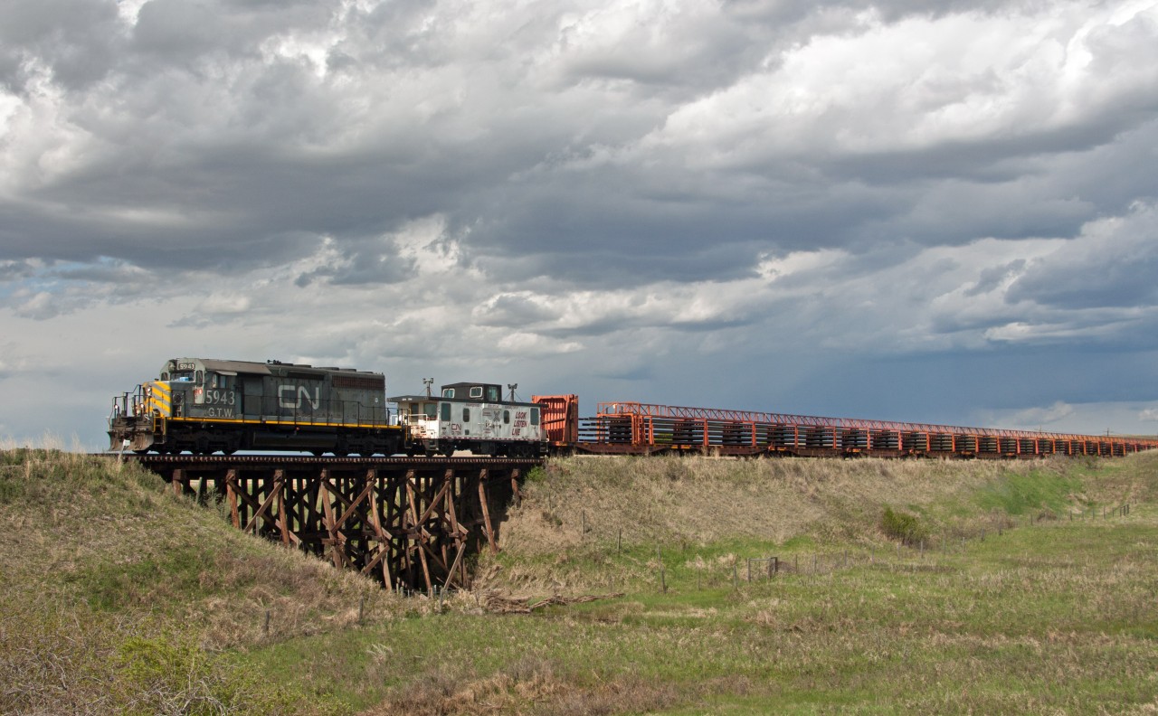 Storm clouds build as the fully loaded rail train removing rail along the CN Drumheller Sub makes it's way back towards Drumheller for the night. This load of rail was from around Delia Alberta. Sad, but interesting to see how they remove the rail. No trains on this part of the line since about 2009.