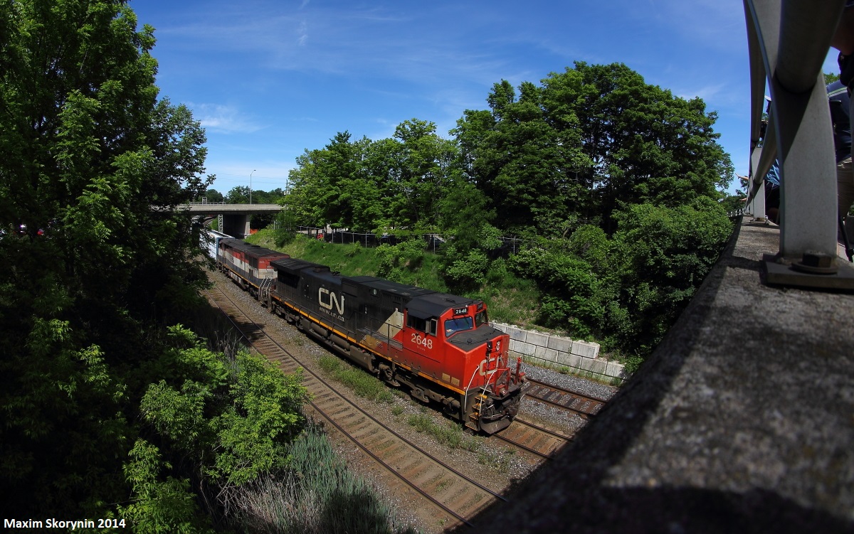 CN train 435 slowly rumbles past the 20th annual meet-up at the Bayview Jct pedestrian bridge with a BCOL cowl in the trail. The perfect light gave me an opportunity to get this neat composition with my 8mm lens, the pedestrian bridge being to the right and the train to the left.