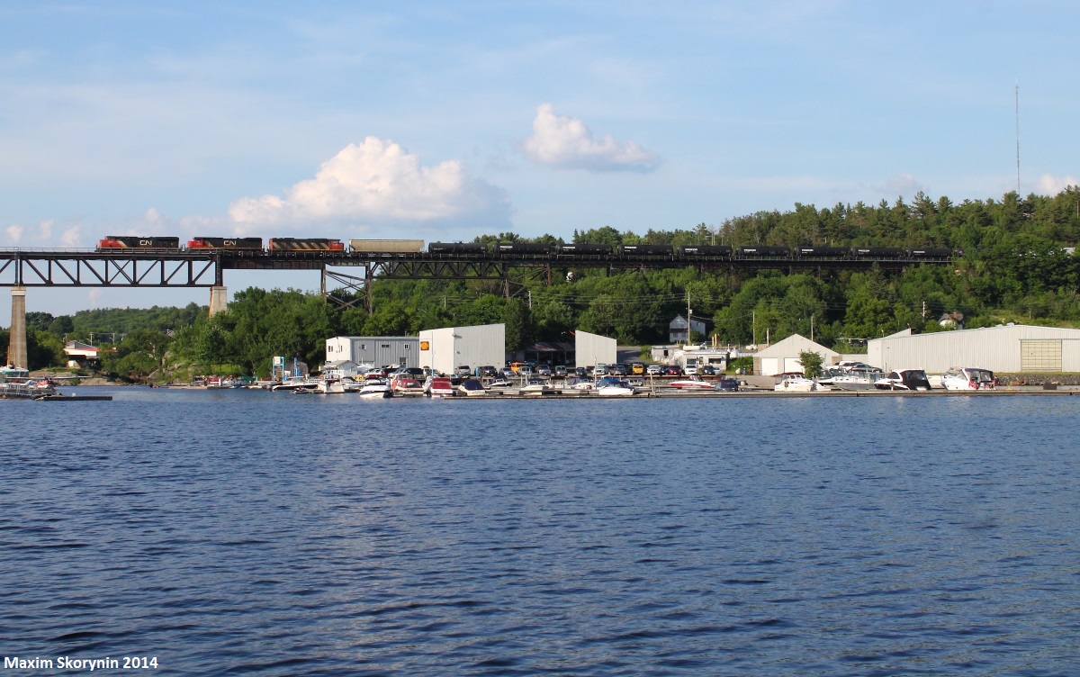 The last train of the day, CN 303 heads through the small town of Parry Sound, ON. The Canadian Pacific trestle, built in the early 1900's, stretches over 1,000 feet long and can be seen from most areas of Parry Sound. This particular photo is taken from the dock where the lighting is perfect in the evenings for the northbounds.