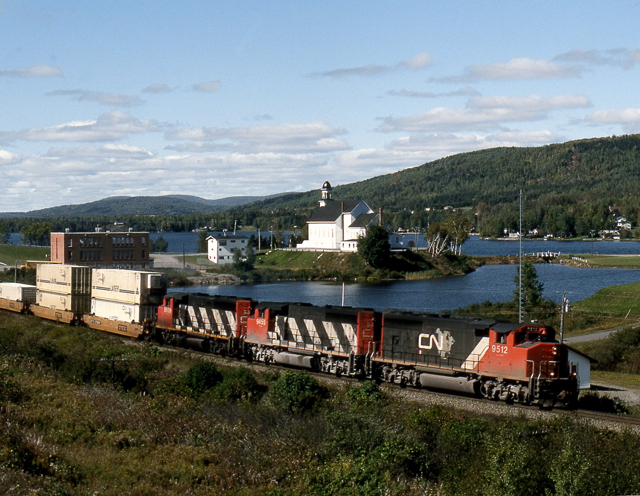 Halifax bound containers have just crossed into New Brunswick from Quebec and pass the Church located on a peninsula in the lake.