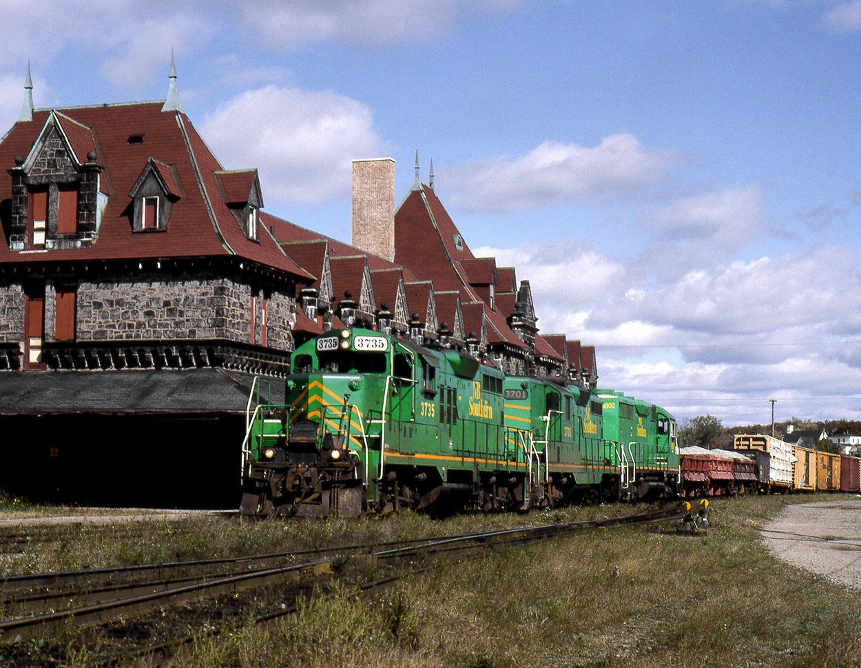 Westbound NBS daily freight makes a set out and pick up in McAdam yard, switching past the backside of the grand former CP hotel and station at what was once CP's centre of operations in the Maritimes.