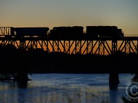 Two generations of EMD power - GP20C-ECO 2263 and GP38-2 3027 form a silhouette against a deep orange sunset at Galt, Ontario. But not a perfect silhouette, as the engineers side numberboards on the eco 2263 are angled enough to properly expose in my frame. Personally, I think it adds to the shot.