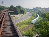 At the height of the rush hour commute, traffic stands still on the Don Valley Parkway in the background. Meanwhile, GO train 836 from Richmond Hill passes under the abandoned "Half-Mile bridge" of the CP Don Branch at Rosedale interlocking. Built it 1928, this bridge is no where near a half mile long, but is definitely enough to make someone look out in awe over the Don Valley, or panic. It was originally intended for freight and passenger service into the Union Station Rail Corridor. However, times changed of course, and the last train ran across this bridge in December 2007, which was the CP Holiday train. 

As you can clearly see, this is a risky shot. There is no railing on the side of the bridge, and the entire Don Branch is filled with thick, sharp and poisonous weeds. The line is completely abandoned, and it would be pretty much physically impossible for a train to access it, however I'd recommend not using it for the above reasons. It's definitely a hazardous trip, and I'm debating even doing it again.