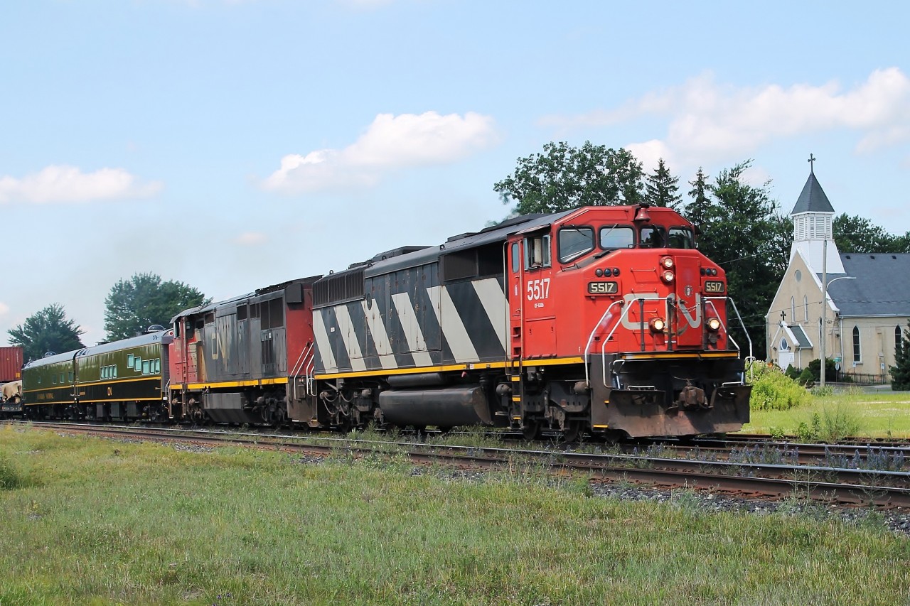 On a sunny day a cloud comes across putting all but 5517's nose in the shade! 5517 and 2440 are pulling an all intermodal east with two Passenger cars in old CN livery-Sanford Fleming and Tawaw.