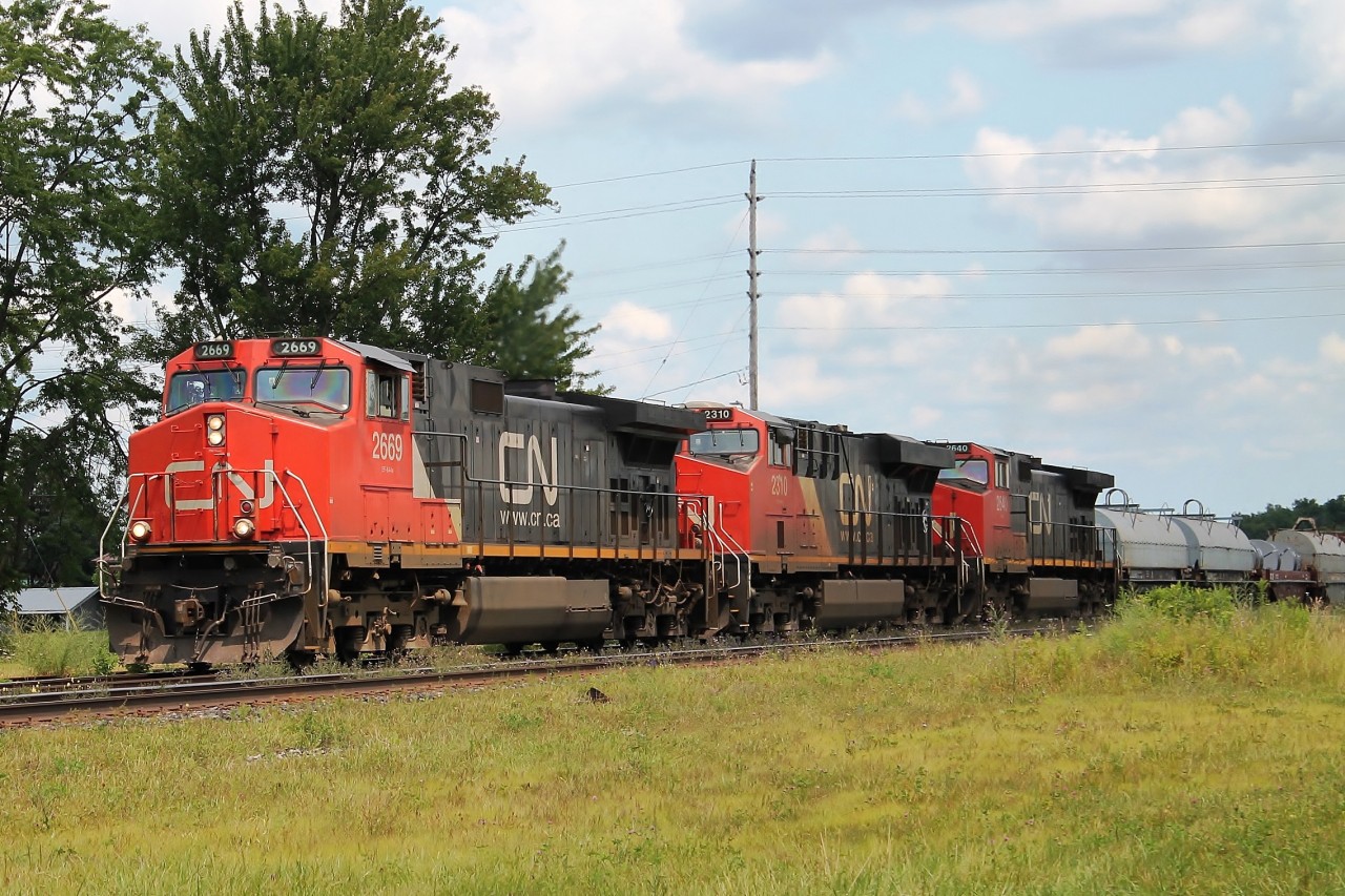 Three GE locos in "elephant formation" 2669,2310,2640 head west on the north track having picked up cars at Paris.