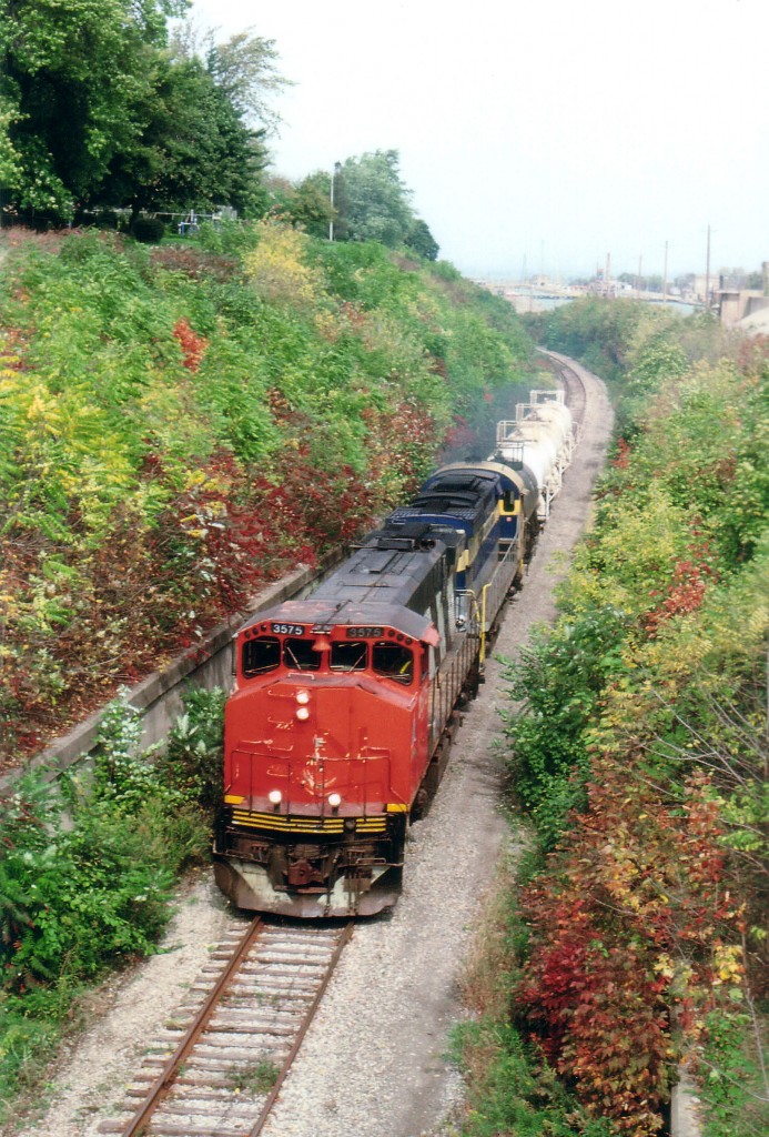 Port Colborne Harbour Railway  3575 (M-420 W) and 6101 (C-425) make their way up the grade alongside the Welland Canal as they haul a short string of tanks from the interchange at CN 9.49 Grimsby Sub into Thorold. The 3575, x-CN, had a very short-lived time on the PCHR, as it was transferred from St. Thomas & Eastern a couple of weeks previously and left for Kelowna BC in the following spring. The trailing unit, 6101, was the "original" locomotive on the PCHR when it started up in July 1997 and went back Stateside in 2001 and over to the Delaware-Lackawanna in 2007. It now works for that road as #2423. And of course the Canadian operation now combines PCHR and STER, and is known as Trillium.