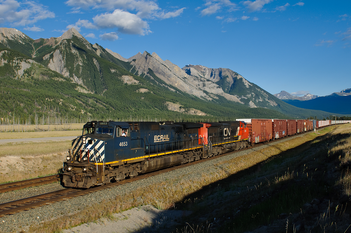 BCOL C44-9W 4653 and CN C40-8 2098 throttle away from Henry House after receiving a better (limited to clear) signal running on the block of train M304 ahead.