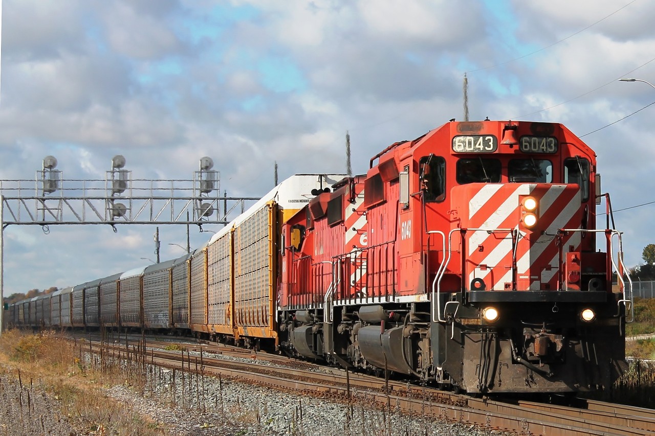 CP 6043 and 6049 leave under threatening skies eastbound from Wolverton yard having collected more autoracks.