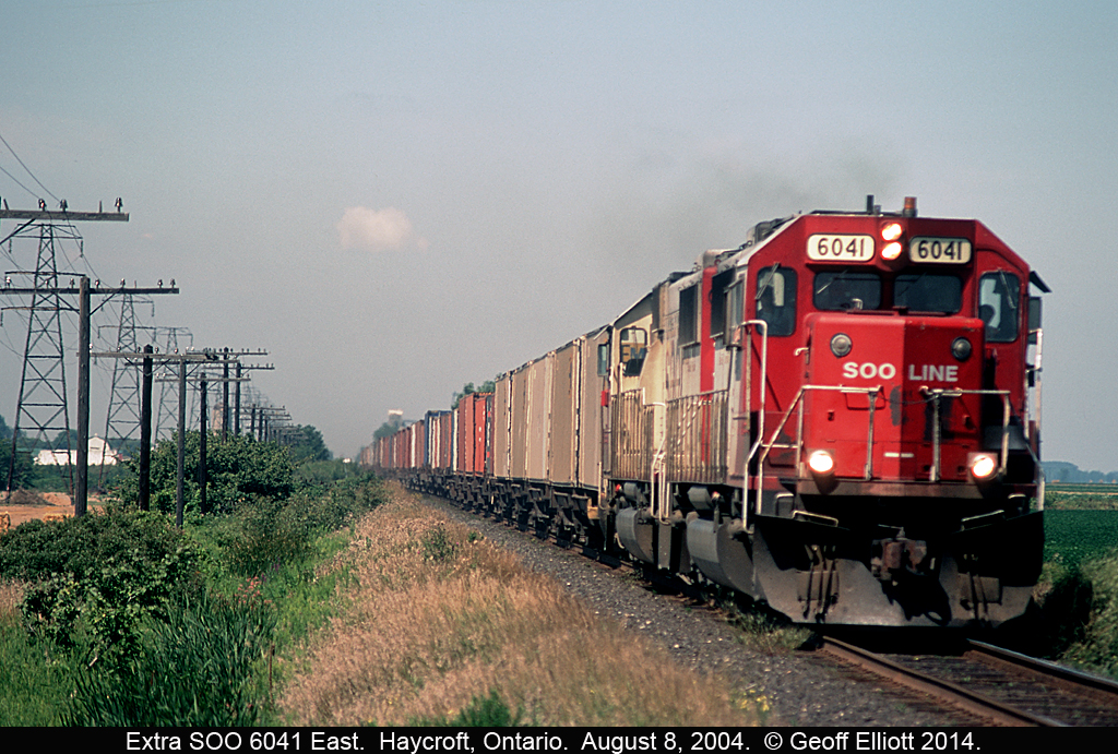 A pair of white SOO SD60's, with 6041 in the lead, are heading quickly east on the CP's Windsor Subdivision between Haycroft and Tilbury, Ontario back in August of 2004.