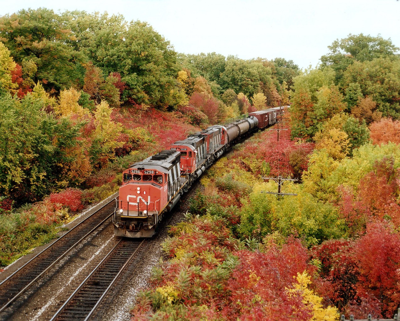 Fall is a favourite time to be trackside. A colour riot like this almost makes one not realize it is actually a dull overcast day. CN 5298, 2339 and 2035 power a train westbound toward Bayview Jct and the Dundas Sub. The scene is from the old Hwy 2 bridge, now known as Plains Road. Years ago I used to identify this location as Bayview East, as it is east of the Jct although this was never a railroad name. Aldershot West, around the bend somewhat, is now known as "Snake", a moniker I am afraid I will never get to appreciate. :o)So it remains, in my mind, Bayview East. As far as I know, lead unit 5298 is still on the CN roster.
