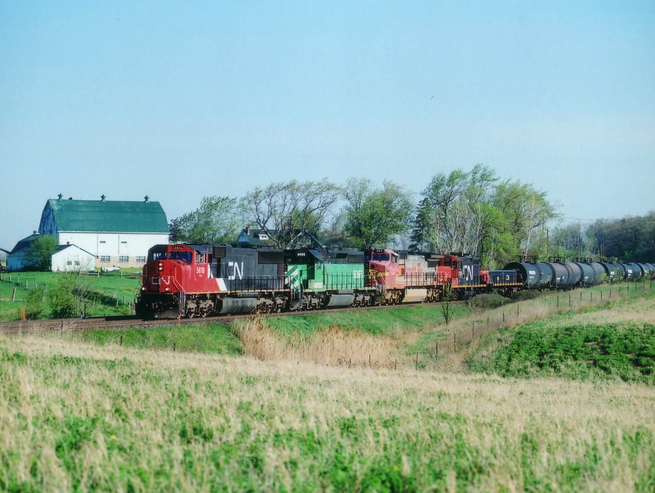 Tansley, a forgotten hamlet north of Burlington, was a nice place to watch the CN back in the days when it actually featured more than a couple of trains in the morning.  The spring sunrise resulted in perfect lighting both ways for a few hours. Here is a nice westbound, with CN 5618, BNSF 8066, 894, CN 7245 & 249. The barn, situated off Tremaine Rd., I used for a prop in many photos. Housing and all the rest of it is expanding in this area at an unbelievable rate as Milton works its way south to join up with Burlington. Days of quiet country settings around here are numbered.