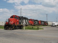 While this job usually pulls a pair, today three rebuilt CN GP9RM's are in charge of local #559. After following them around Brampton as they working a few industries on the mainline, 4112, 7068 and 7071 are seen backing down the Peel Village Industrial Lead in Brampton to switch out Canada Colours & Chemicals, and Graphic Packaging off Kennedy Road, seen here crossing Stafford Drive.
<br><br>
Built in the 1950's and remanufactured in the 1980's, a large majority of those 60 year old units that killed off steam engines are still working for CN in local, yard and industrial service, doing the work more modern and powerful units are too large and overpowered for.
<br><br>
<b><i>More #559 in Brampton:</i></b><br>
Switching Canwel off the mainline: <a href=http://www.railpictures.ca/?attachment_id=4751><b>http://www.railpictures.ca/?attachment_id=4751</b></a><br>
Working the Torbram Industrial Lead along Steeles: <a href=http://www.railpictures.ca/?attachment_id=8966><b>http://www.railpictures.ca/?attachment_id=8966</b></a><br>
Working the Dixie Cup Spur: <a href=http://www.railpictures.ca/?attachment_id=3744><b>http://www.railpictures.ca/?attachment_id=3744</b></a><br>
Protecting the crossing: <a href=http://www.railpictures.ca/?attachment_id=8980><b>http://www.railpictures.ca/?attachment_id=8980</b></a><br>
Backing into Malport Yard: <a href=http://www.railpictures.ca/?attachment_id=3795><b>http://www.railpictures.ca/?attachment_id=3795</b></a>