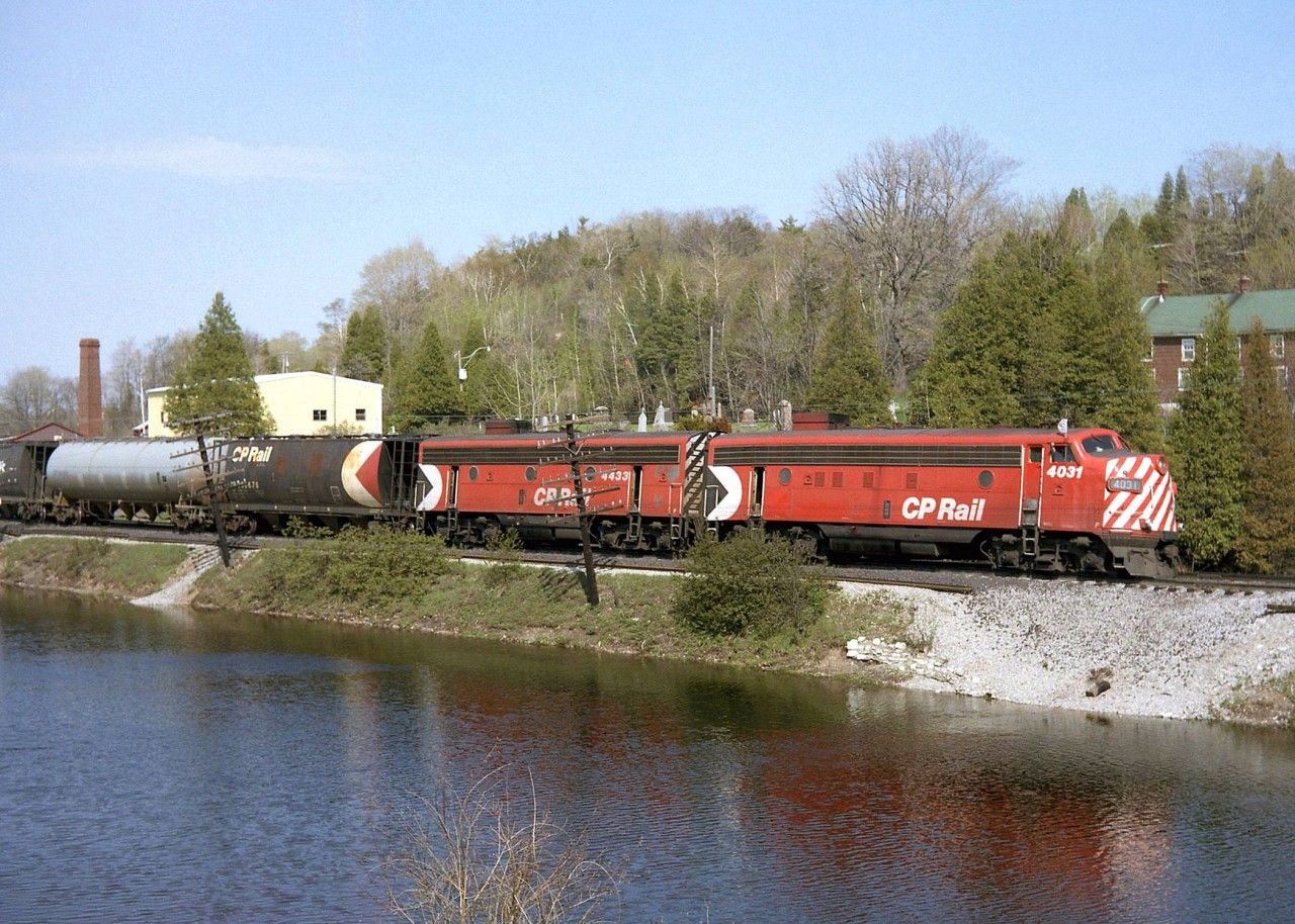 An A-B pair of matching F-units in CP's Action Red, FP7 4031 and F7B 4433, head west on the Galt Sub through Campbellville passing the ponds. Also of note are the early design cylindrical hoppers behind, bracketing a grey pressure-flow covered hopper. This scene is a difficult shot today due to the foliage growth.

The remaining GMD F-unit fleet on CP only had a few more years to go, before being retired en masse in 1982 (although a few remained in Montreal commuter service before going to CTCUM).