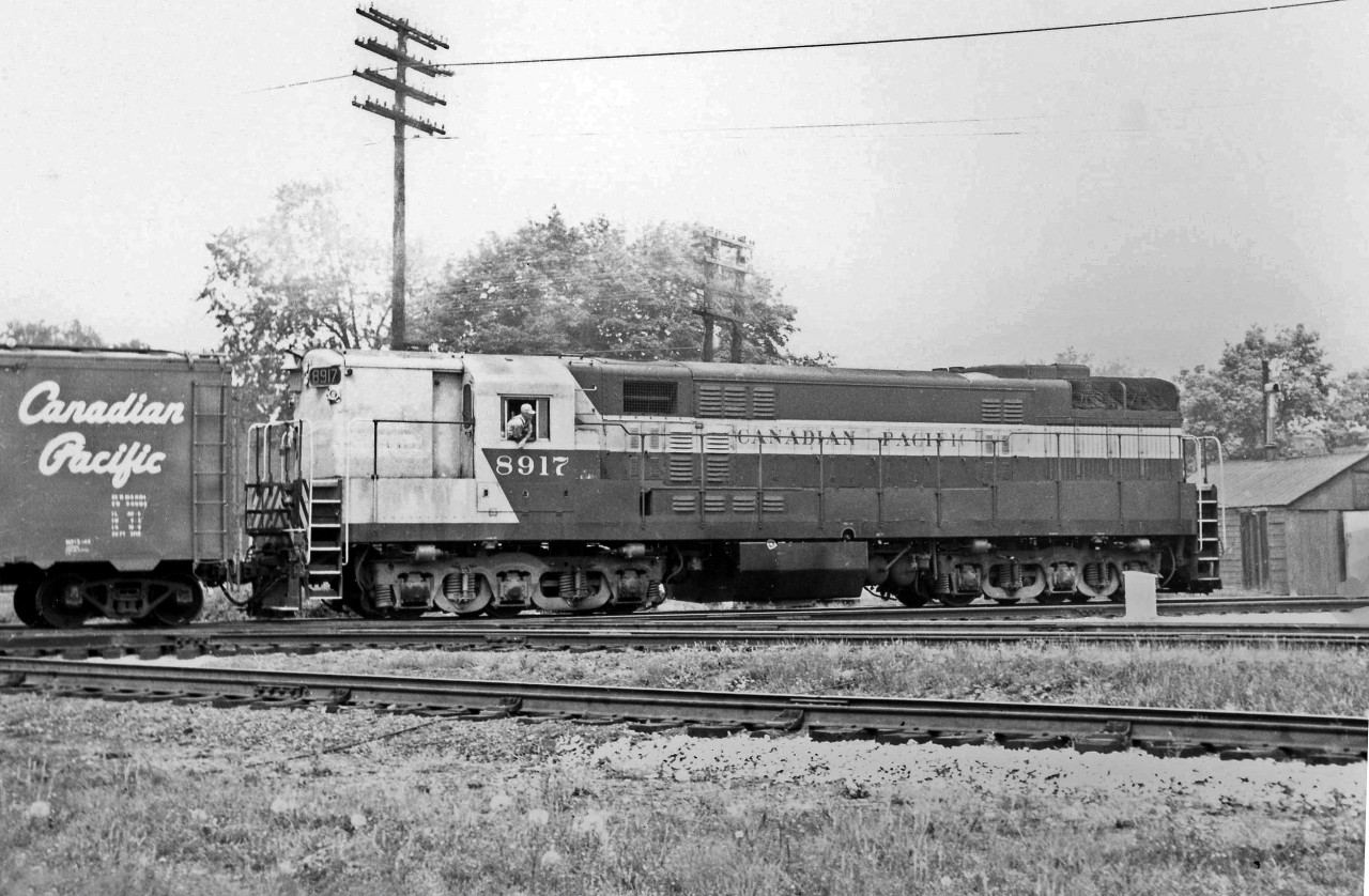 Another shot of Trainmasters working around West Toronto: CP 8917 runs long-hood forward heading east on the CP's North Toronto Sub, crossing the West Toronto diamonds, likely working a West Toronto to Toronto Yard (Agincourt) transfer. The large 3-axle FM-style Trimount trucks are visible here. When a group of TM's were retired in the late 60's, a number of units had their traction motors removed from them and reused in new MLW C630M's.  The 21 FM/CLC H24-66's as well as a number of 8500 and 8600 series H16-44's were originally set up to run long hood forward (LHF) and painted as such, but most were converted to short hood forward (SHF) operation after a number of years, as is 8917 here. Even though all the Trainmasters were converted to SHF operation, one or two H16's such as 8554 and 8555 were left LHF until retirement, despite being repainted in the multimark as if they were SHF.  More at West Toronto: CP doubleheader leaving the station: http://www.railpictures.ca/?attachment_id=14058 CP 8917 from old Weston Road bridge: http://www.railpictures.ca/?attachment_id=15874 CN Steam with the interlocking tower: http://www.railpictures.ca/?attachment_id=16093 CP 8919 near West Toronto station: http://www.railpictures.ca/?attachment_id=15951