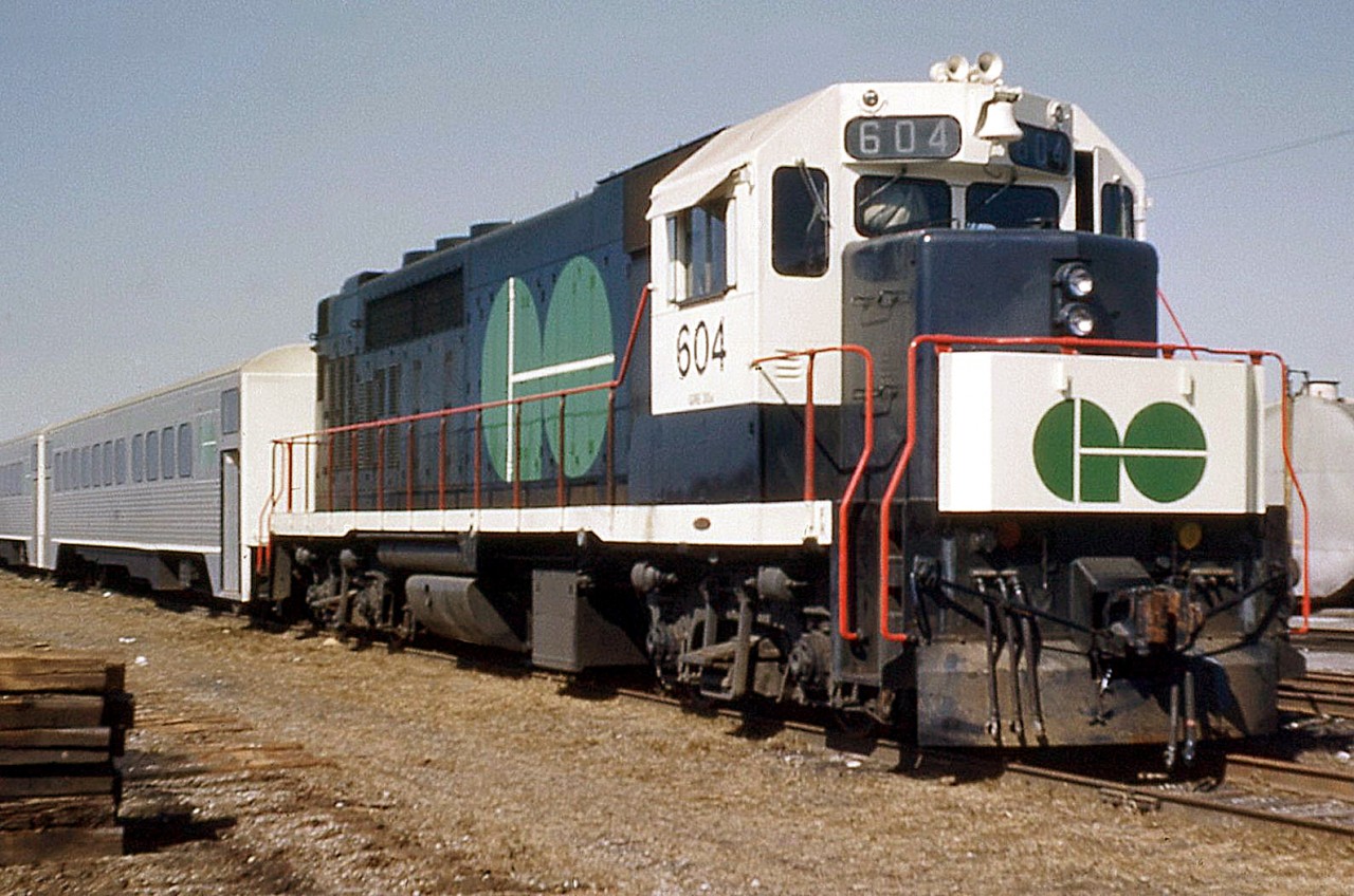 Painted in its proper colours from the "stealth" version it and its sisters wore in brief CN freight service, GO 604 is seen parked with a train of Hawker Siddeley Canada single-level commuter cars (based on the HSC RT-75 / TTC "H-series" subway car design) at Mimico in 1967. Of note, GO trains were maintained out of an old CN carshop in CN's old Mimico yards before the construction of Willowbrook shop a number of years later.

Before the official startup of GO Transit, these units did temporary runs in CN freight service in a modified paint scheme: http://www.railpictures.ca/?attachment_id=15870
