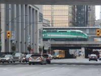 A GO train pauses over Bay Street in downtown Toronto.