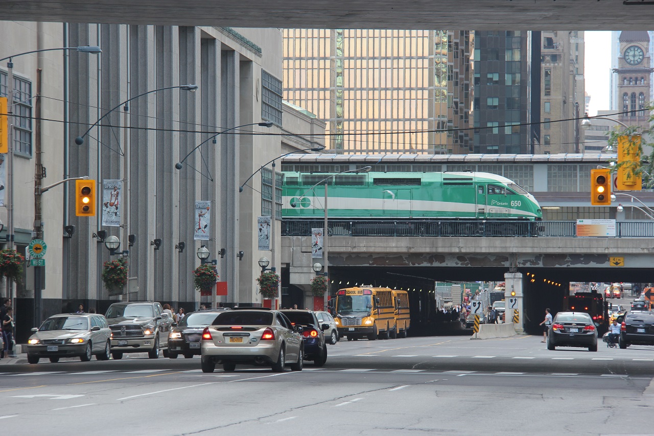A GO train pauses over Bay Street in downtown Toronto.